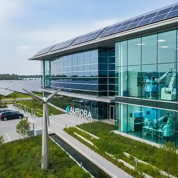 Fachada moderna de um prédio de vidro representando um parque tecnológico com áreas verdes ao redor